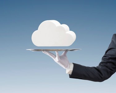 Businessman offering white cloud on silver tray over blue background